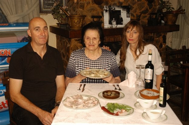 Pepita posa con sus hijos José Antonio y Yolanda, el plato de cocochas de bacalao y los ingredientes.