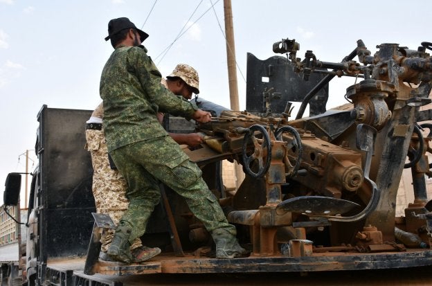 Soldados del ejército de El-Asad preparan una pieza de artillería al este de la ciudad de Deir Ezzor. :: G. OURFALIAN / AFP