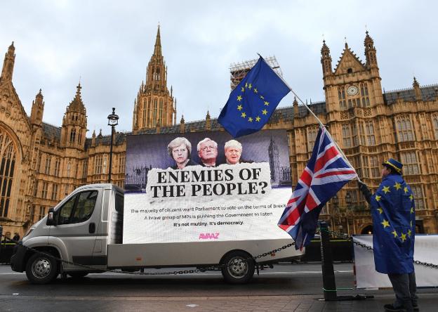 Un hombre, con una bandera europea o otra británica, ayer en una protesta contra el 'brexit' ante el Parlamento de Londres. :: F. A. / efe
/