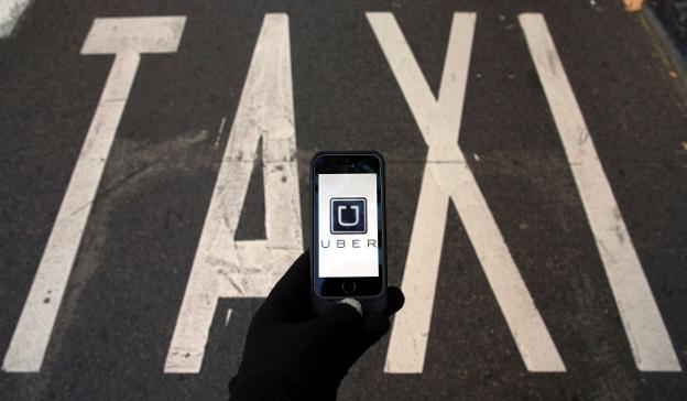 Una persona trata de abrir la aplicación digital de Uber en una parada de taxi.. :: s. pérez / reuters/