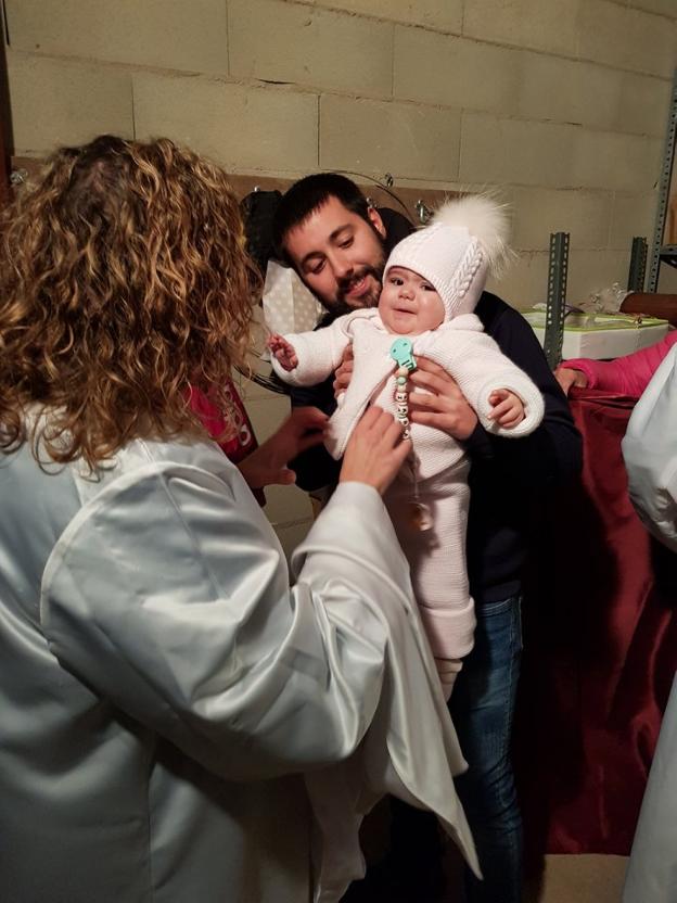 Ana (Virgen María) y Pablo (San José) vistiendo a Iara (Niño Jesús). :: m.f./