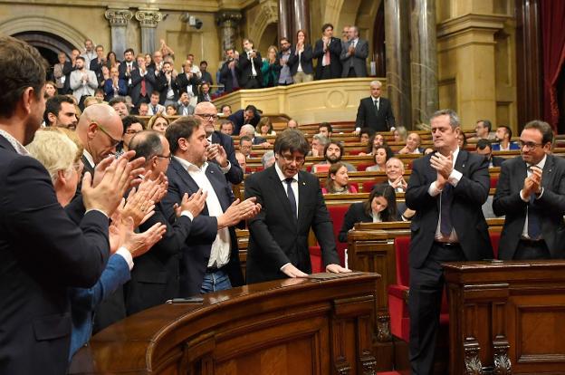 Diputados independentistas aplauden a Puigdemont tras su discurso del 10 de octubre en el Parlament. :: LLUIS GEné / afp/