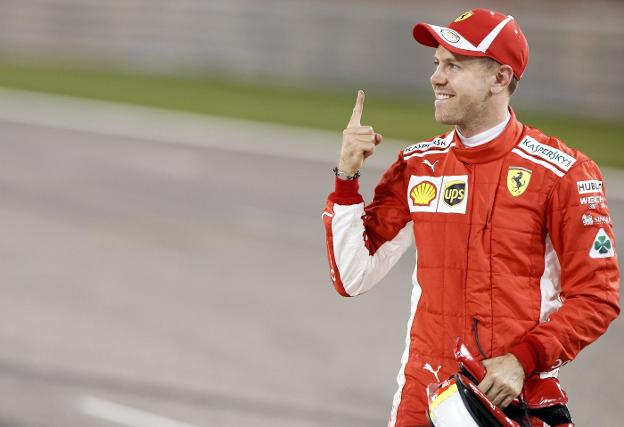 El piloto alemán Sebastian Vettel levanta su dedo índice tras lograr ayer la 'pole' en el circuito de Sakhir. :: VALDRIN XHEMAJ / EFE/