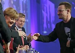 Bono, vocalista de la banda irlandesa U2, saluda a la canciller Merkel. / Juanjo Martín (Efe) | Vídeo: Atlas/