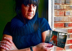 Yolanda Puig muestra la fotografía de su hermana Mónica, asesinada por su marido en el 2003. / MIGUEL HERREROS/