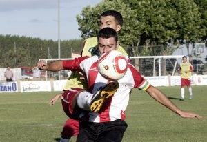 El jugador de la Sociedad Deportiva Logroñés Javi Gómez pelea por el esférico con Íñigo Eguren, defensa del Berceo. :: MIGUEL HERREROS/
