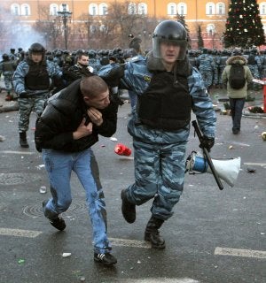 Un policía ruso lleva arrestado a un ultra durante los disturbios producidos en Moscú el 11 de diciembre. ::
AFP/